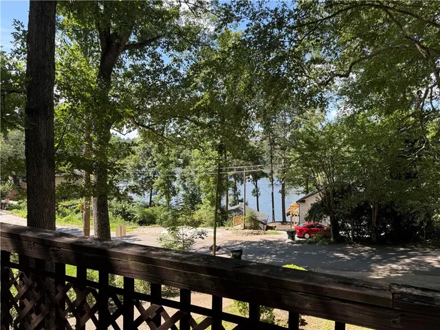 a view of street with trees and wooden fence