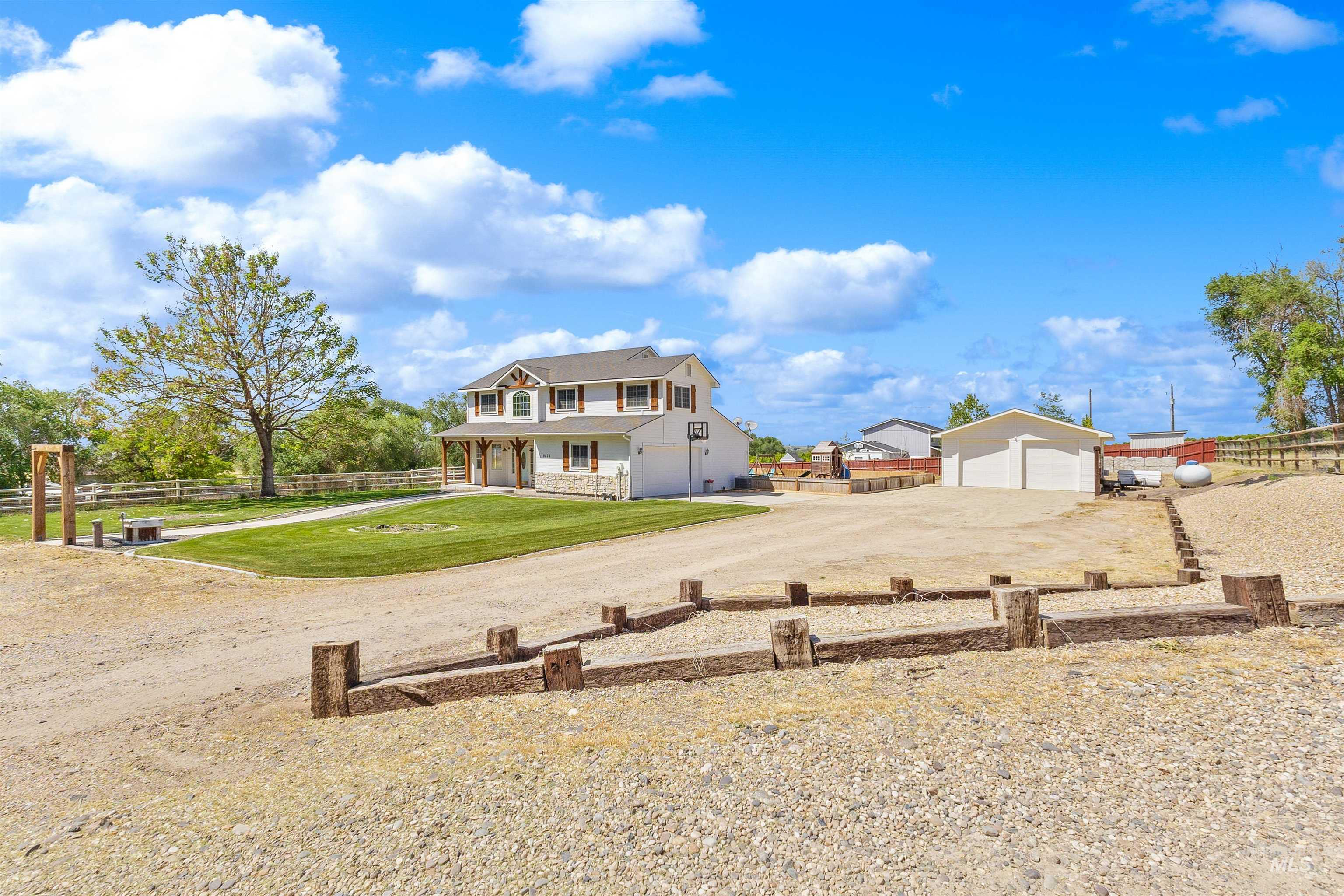19876 Scotts Lane Caldwell, ID 83607 - Photo 11 of 44 Expansive gravel parking area featuring a two-story residence with a covered porch and white siding and shop