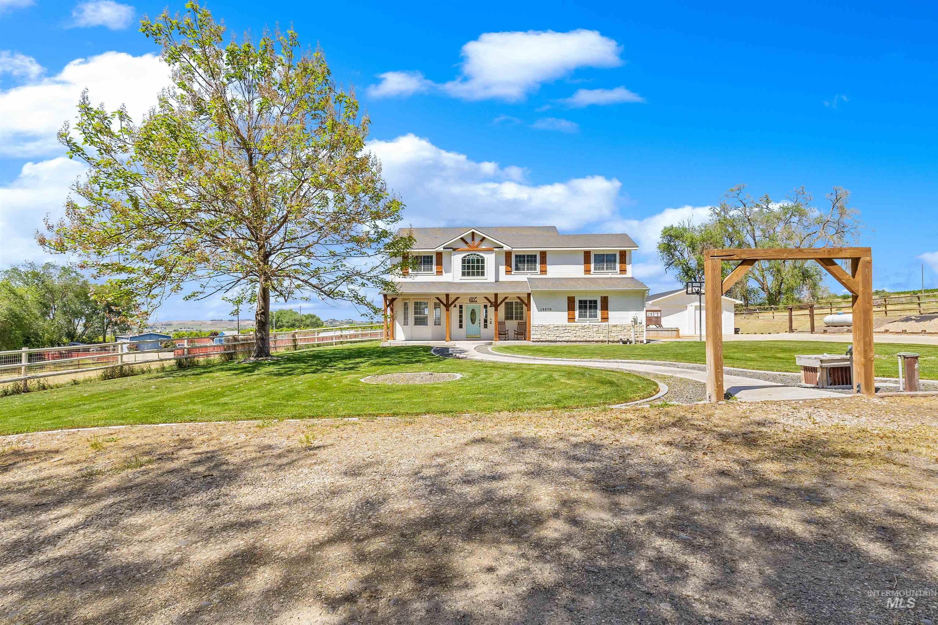 19876 Scotts Lane Caldwell, ID 83607 - Photo 2 of 44 Two-story residence featuring white siding and stone accents, Shaded Driveway and flowering tree