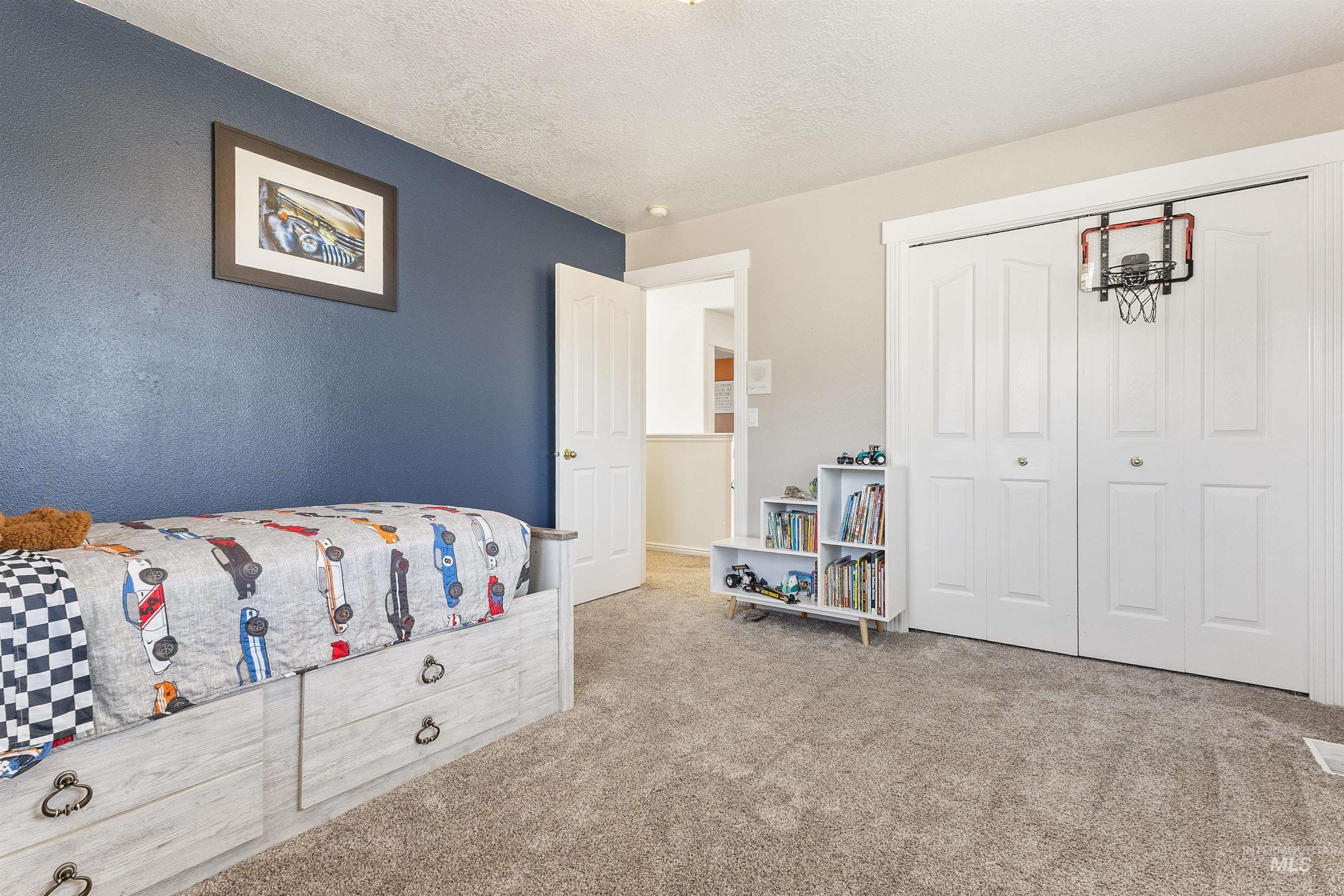 19876 Scotts Lane Caldwell, ID 83607 - Photo 41 of 44 Carpeted interior room with a textured blue accent wall