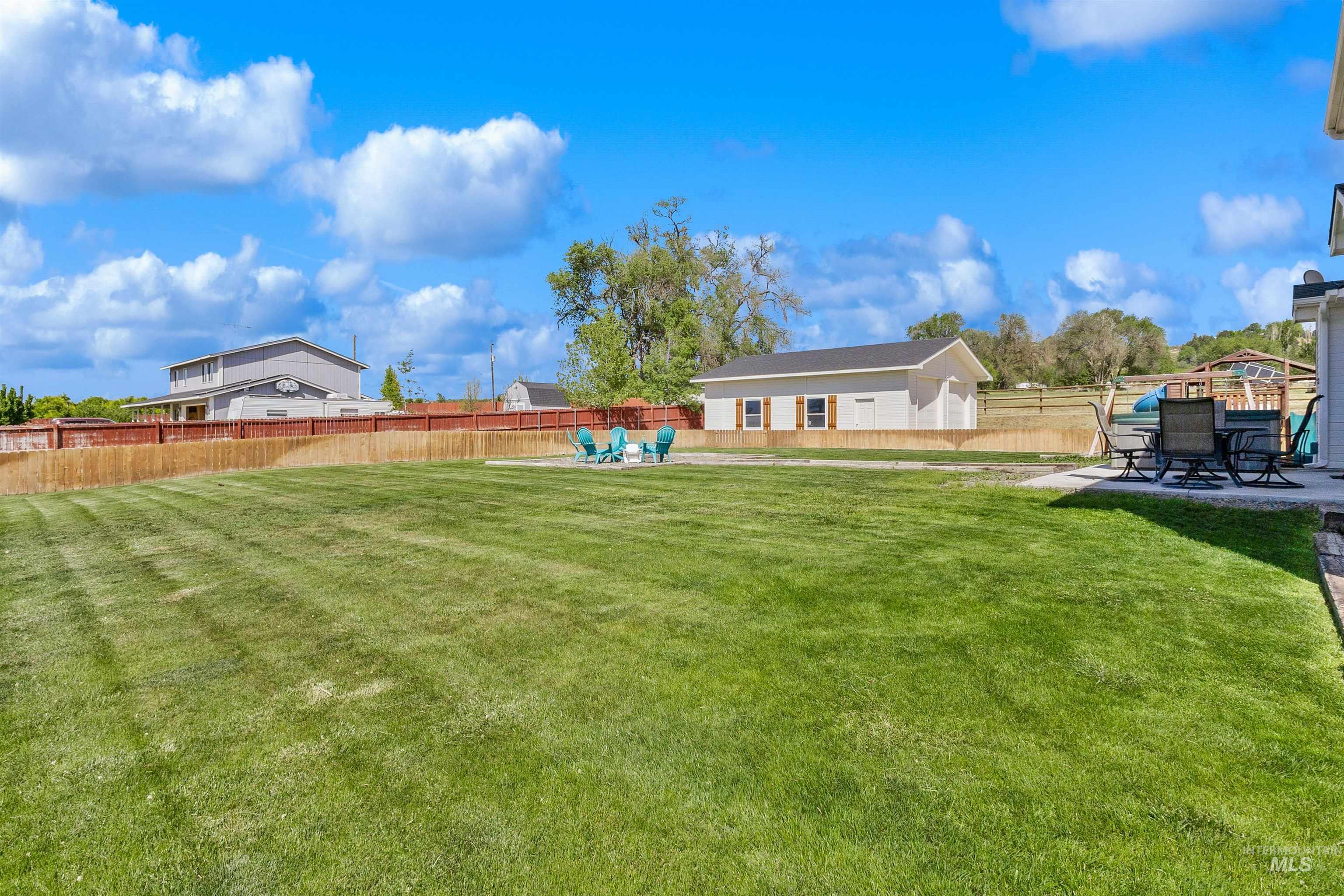 19876 Scotts Lane Caldwell, ID 83607 - Photo 6 of 44 Expansive green lawn with a defined perimeter fence and view of the shop