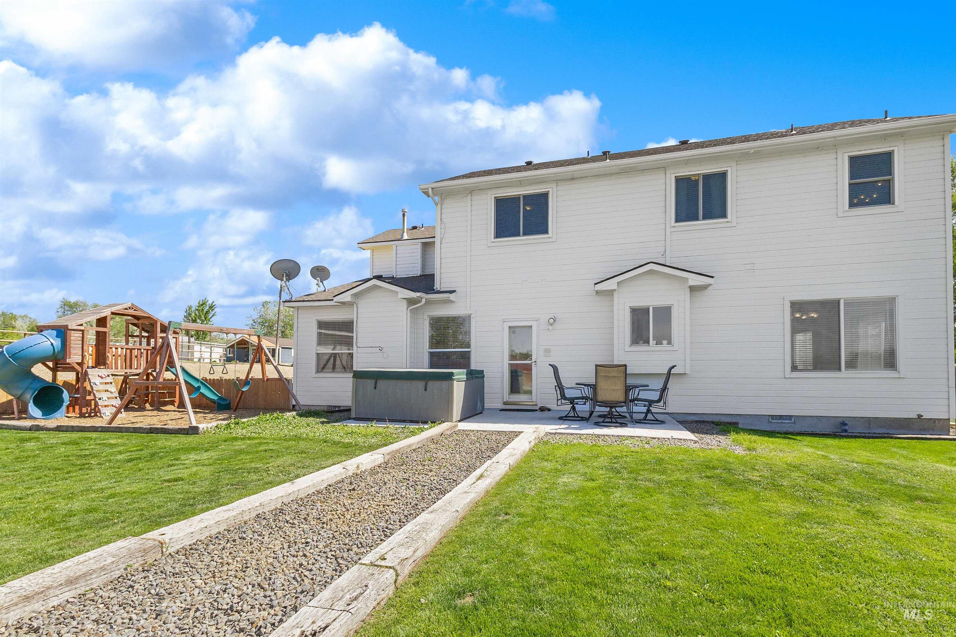 19876 Scotts Lane Caldwell, ID 83607 - Photo 8 of 44 Spacious backyard featuring a lush lawn, concrete patio, and a dedicated play structure, and Eating area