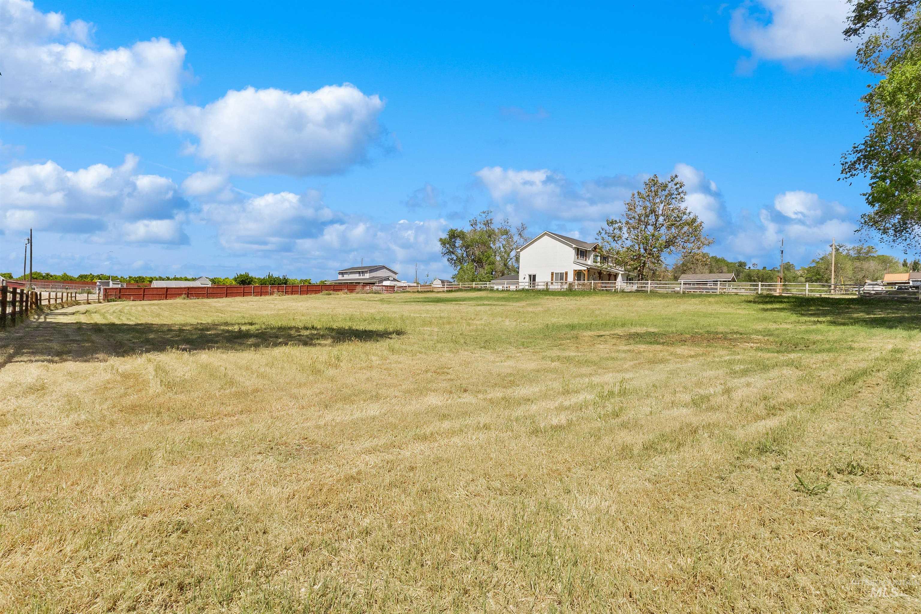 19876 Scotts Lane Caldwell, ID 83607 - Photo 10 of 44 Expansive grassy pasture from the front corner with perimeter fencing and a two-story residence