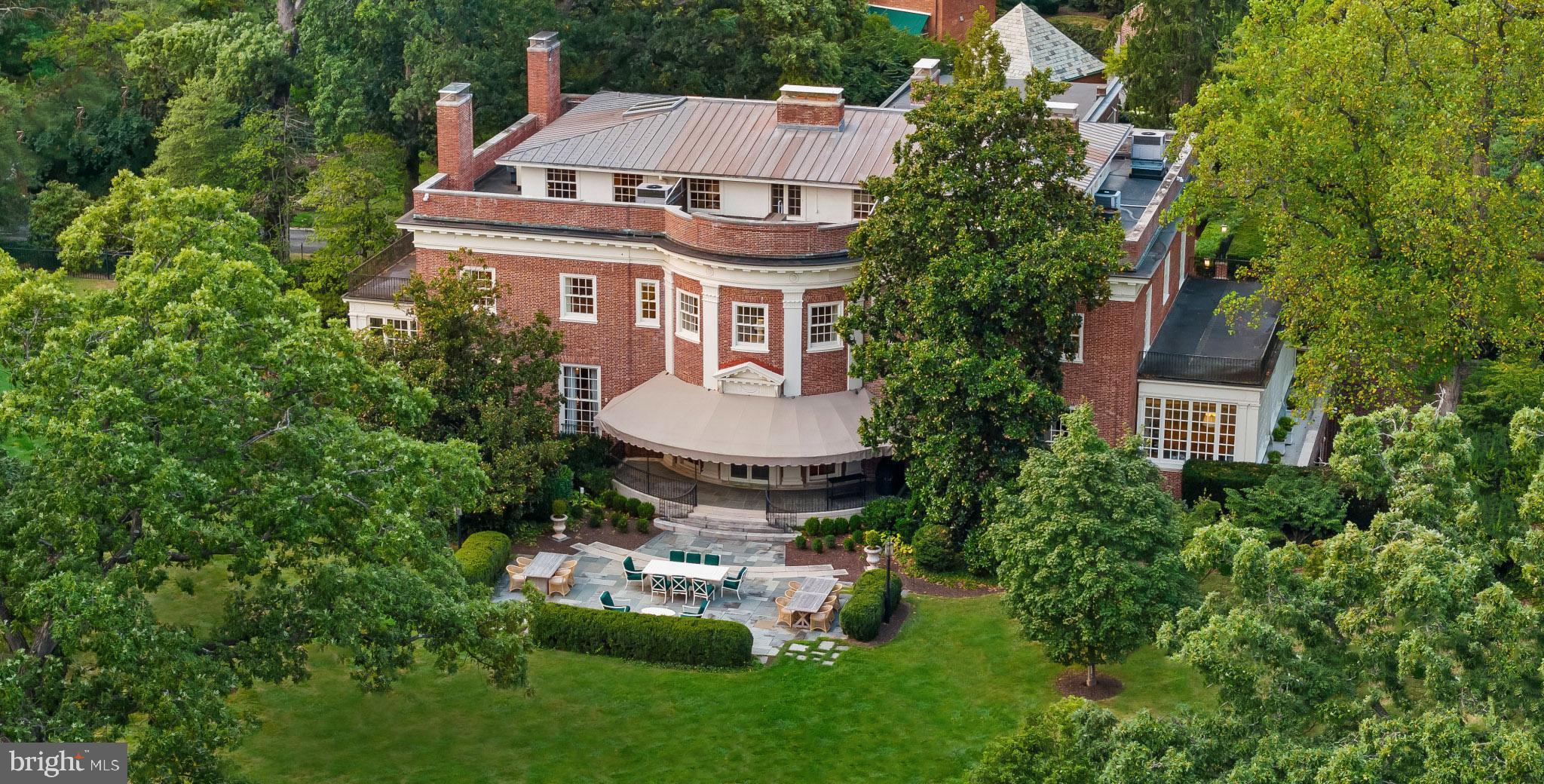 an aerial view of a house with garden space and trees all around