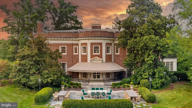 a front view of a house with garden and trees