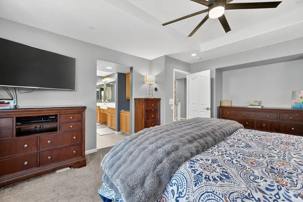 a bedroom with a bed and a flat tv screen on dresser