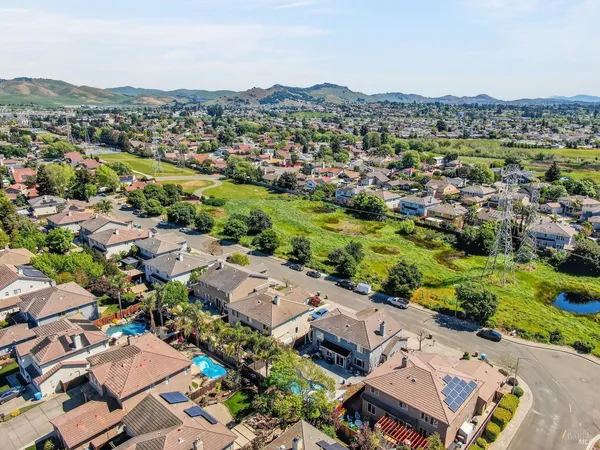 an aerial view of ocean and residential houses with outdoor space
