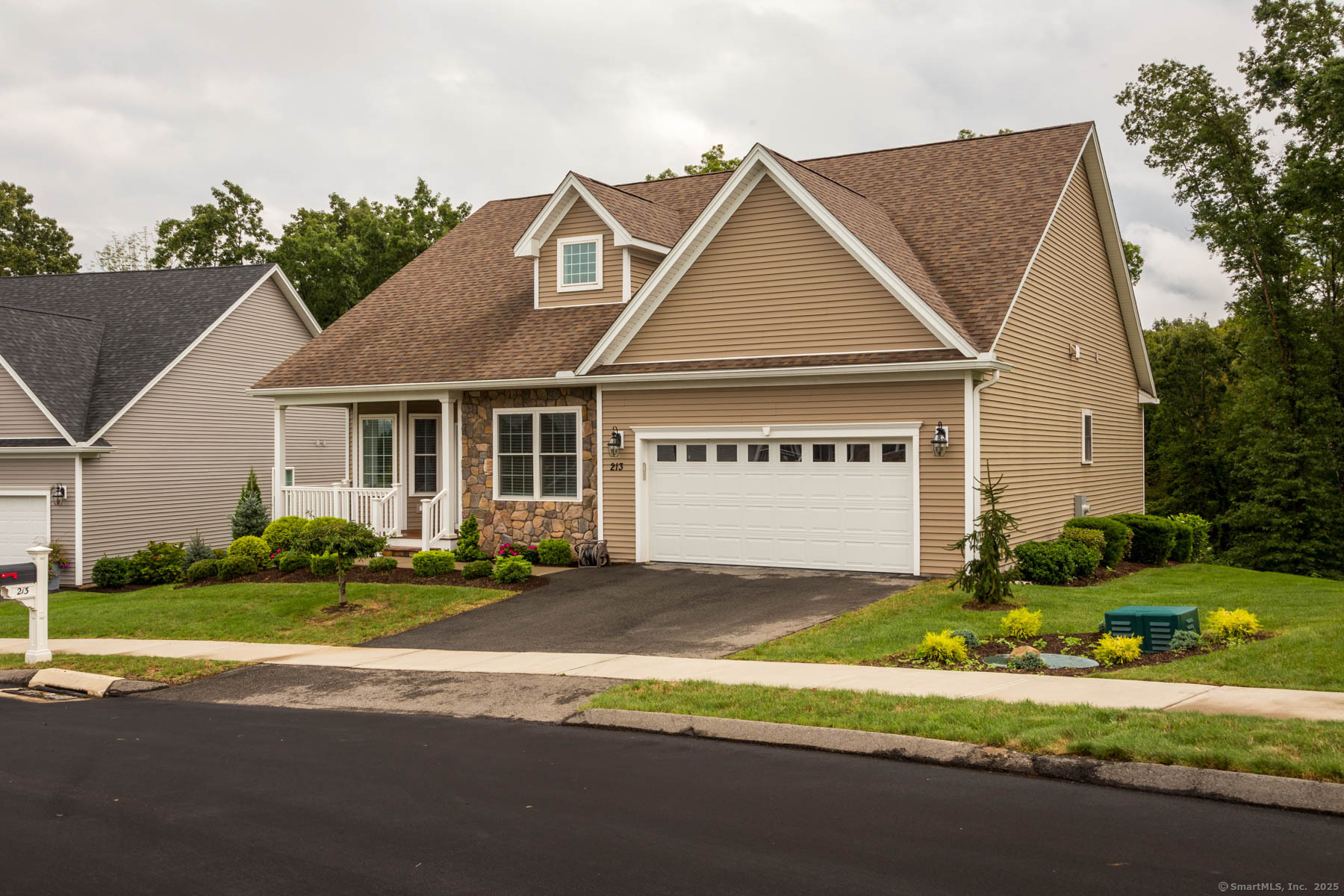 a front view of a house with a garden and plants