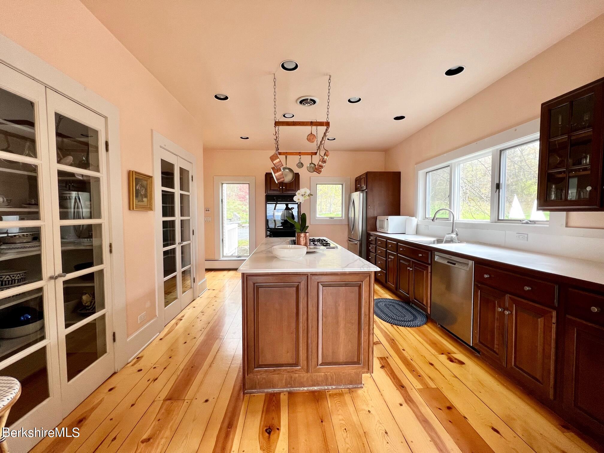 169 Mt Hunger Road Monterey, MA 01245 - Photo 21 of 51 a large kitchen with kitchen island wooden floors wooden cabinets a sink and appliances