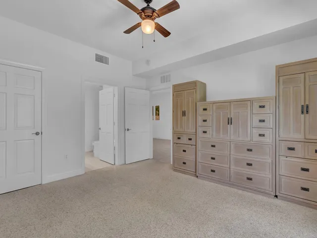 a view of a bedroom with cabinet cabinet and windows