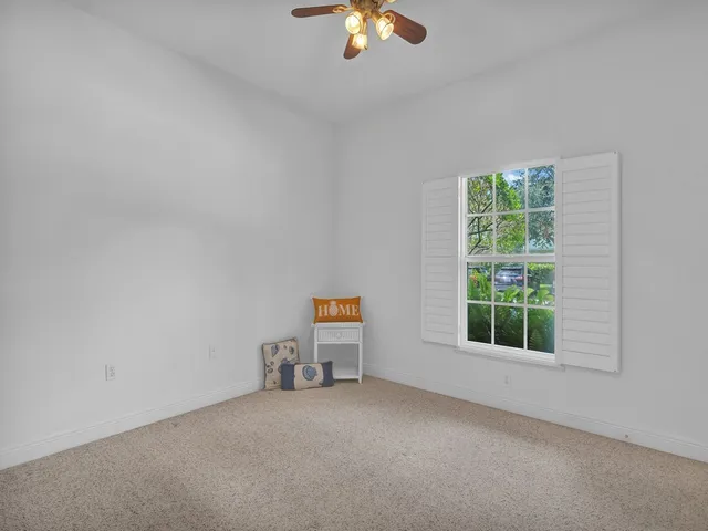 an empty room with a window and a ceiling fan