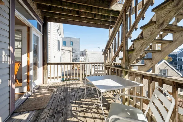 a view of backyard with table and chairs and wooden fence