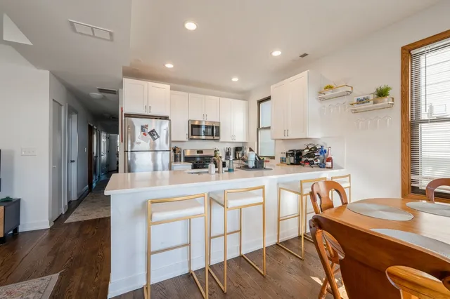 a kitchen with white cabinets and refrigerator