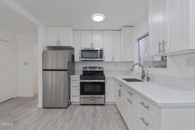 a kitchen with a sink stove and refrigerator