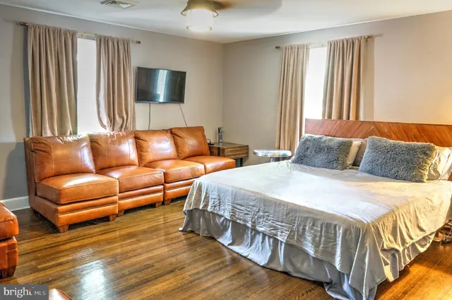 a bedroom with furniture and a flat screen tv