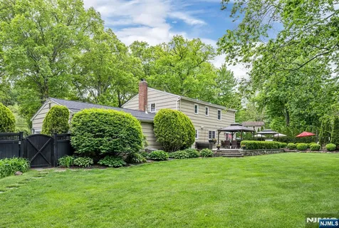 a front view of a house with a yard and trees