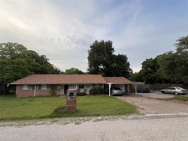 a front view of a house with a garden and yard