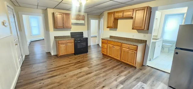a large kitchen with stainless steel appliances granite countertop a stove and a refrigerator