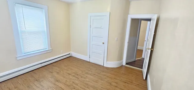 an empty room with wooden floor and closet