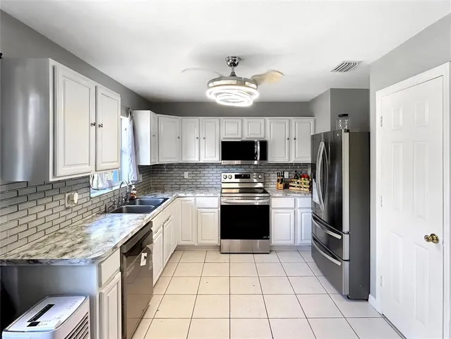 a kitchen with a stove a sink and a refrigerator