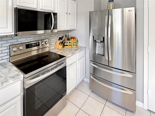 a kitchen with stainless steel appliances a stove microwave and refrigerator