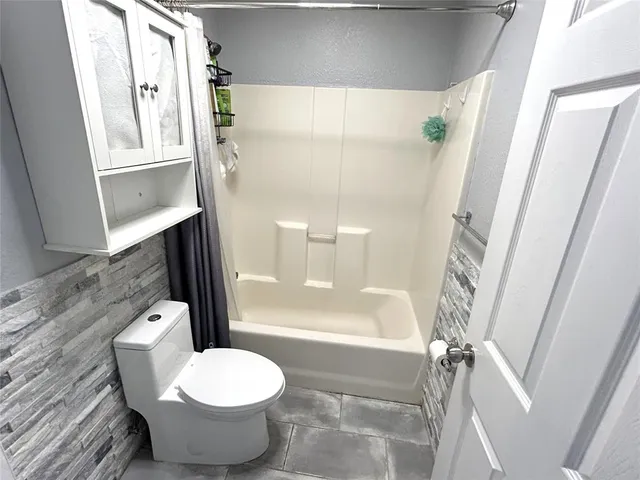 a bathroom with a toilet and a shower