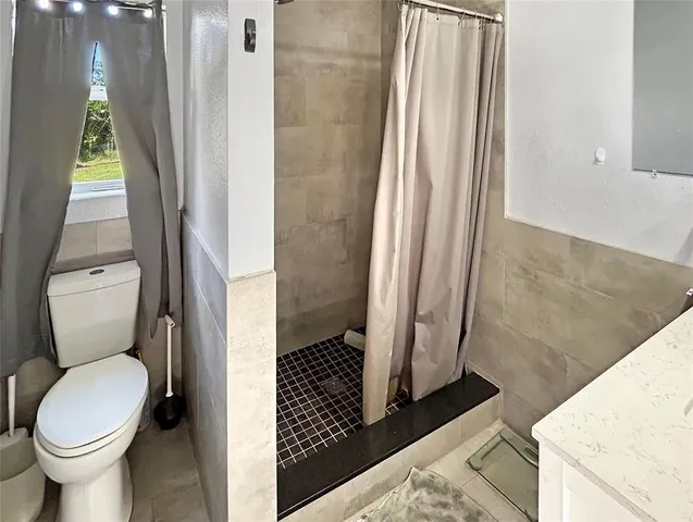 a bathroom with a toilet and a shower
