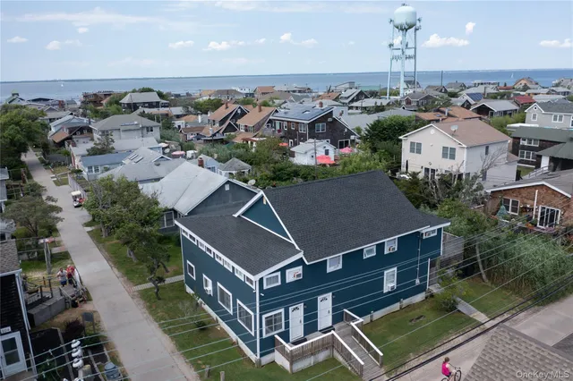 an aerial view of multiple houses with a yard
