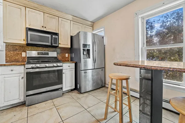 a kitchen with stainless steel appliances a stove a refrigerator and a microwave