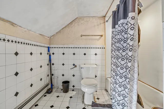 a bathroom with a toilet and a shower