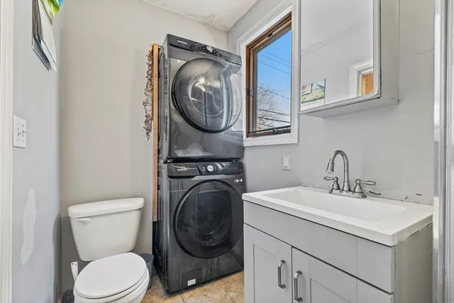 a bathroom with a toilet sink vanity and mirror