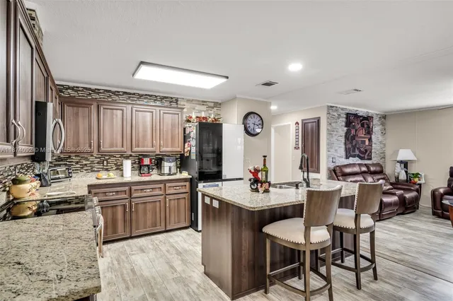 a kitchen with lots of counter top space and painting on the wall