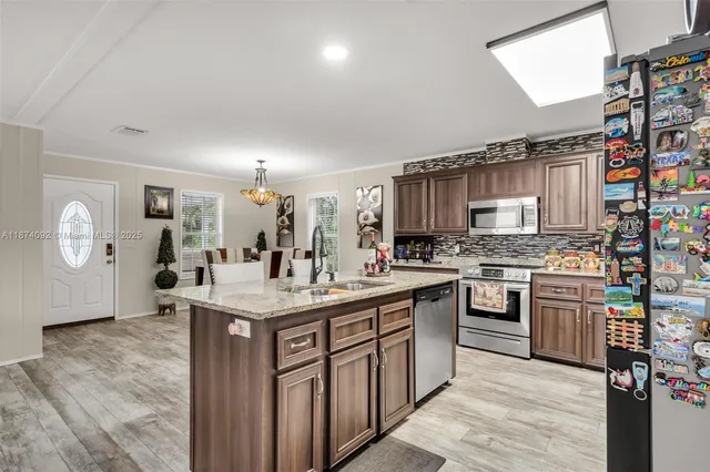 a kitchen with stainless steel appliances granite countertop a stove cabinets and wooden floor