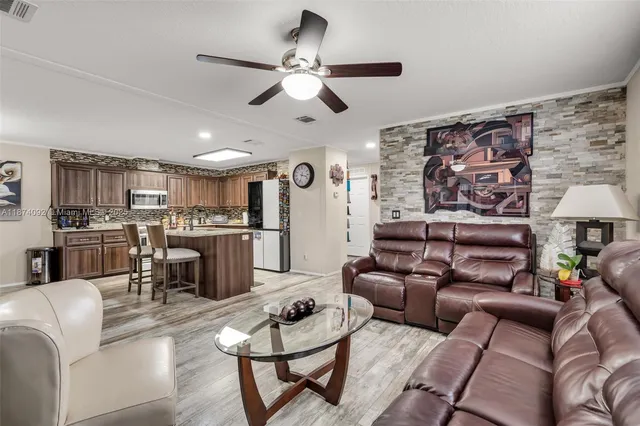 a living room with furniture kitchen view and a chandelier