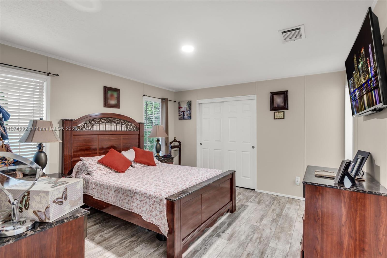 12850 West State Road, Unit 1 Davie, FL 33325 - Photo 6 of 32 a bedroom with a bed and a potted plant on the dresser