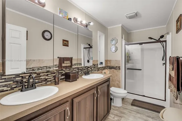 a bathroom with a sink a toilet a mirror and shower