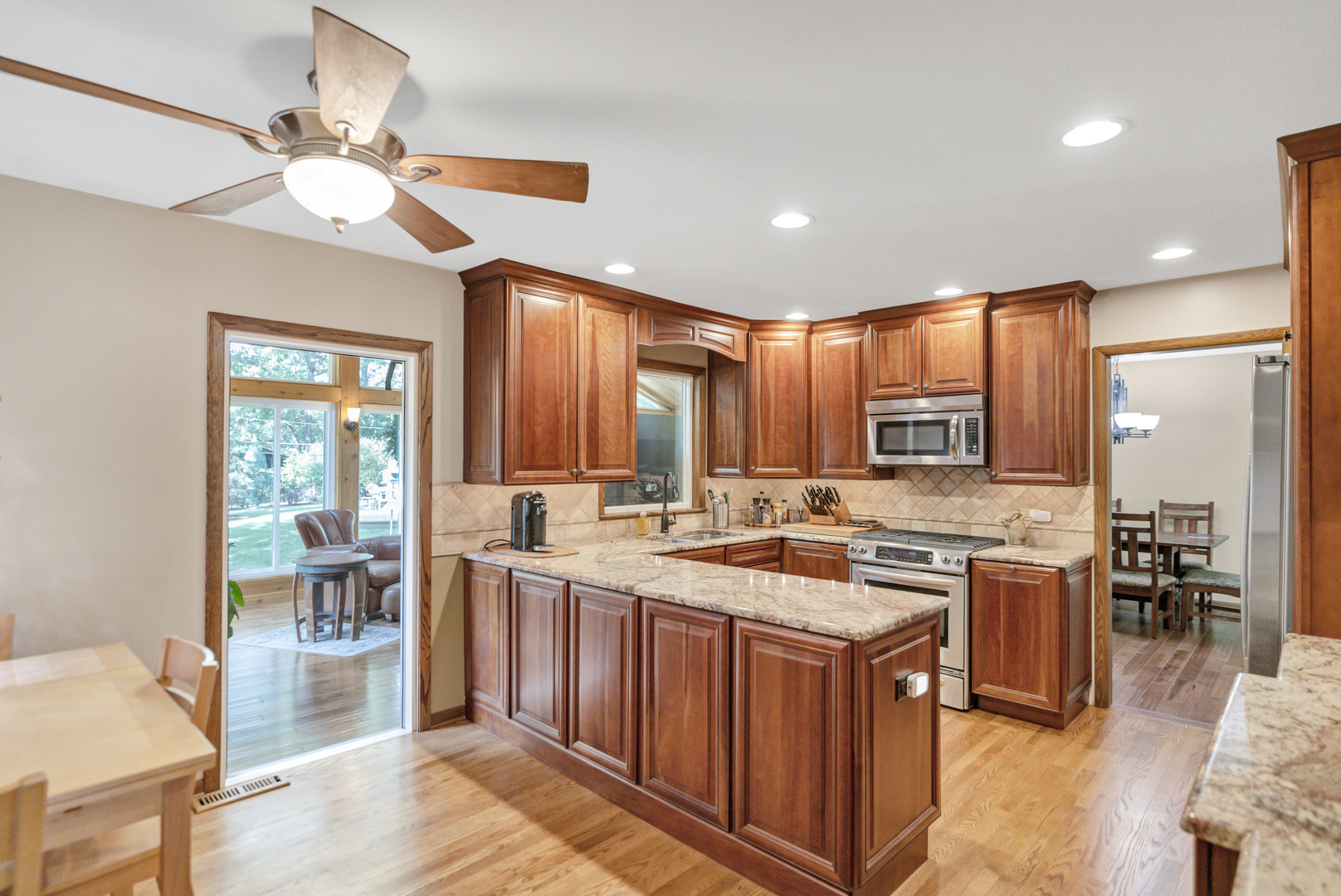 512 Forest Drive Addison, IL 60101 - Photo 28 of 61 a kitchen with a stove a sink dishwasher and a dining table with wooden floor