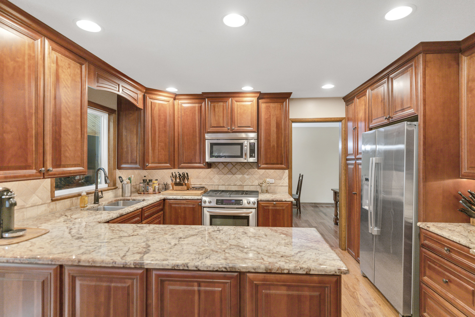 512 Forest Drive Addison, IL 60101 - Photo 29 of 61 a kitchen with kitchen island granite countertop a sink stove refrigerator and cabinets
