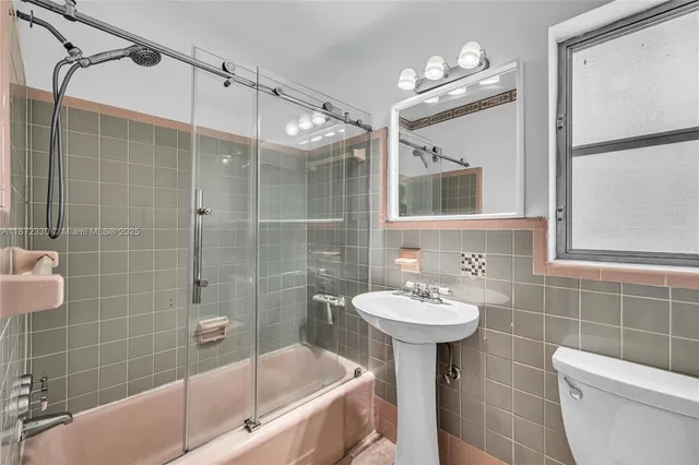 a bathroom with a sink mirror toilet shower and bathtub