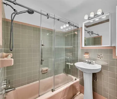 a bathroom with a sink mirror toilet shower and bathtub