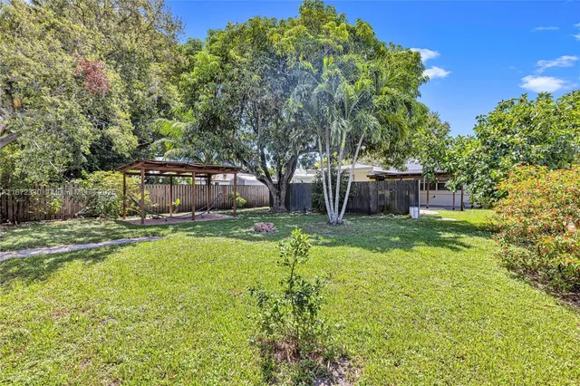 a view of a house with backyard and a sitting area