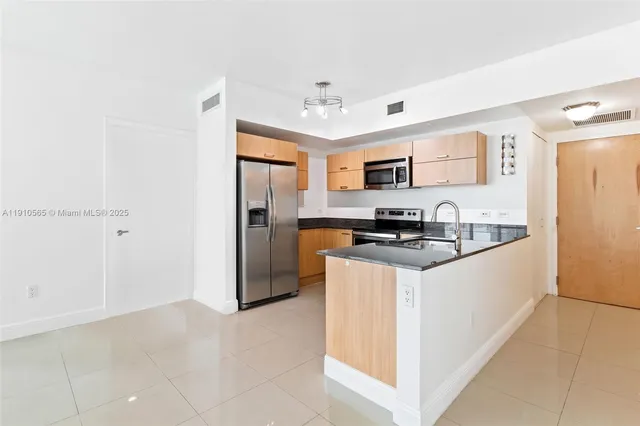 a kitchen with stainless steel appliances granite countertop a refrigerator stove and a sink
