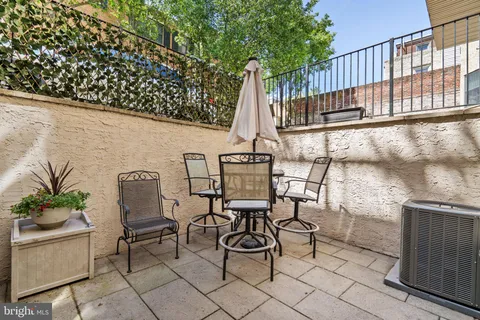a kitchen with stainless steel appliances granite countertop a stove a refrigerator a kitchen island a table and chairs