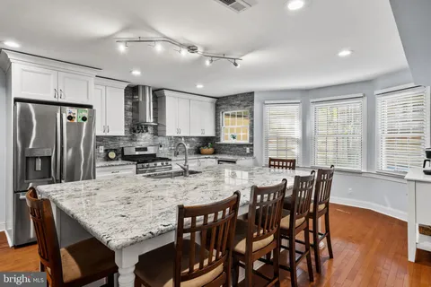 a kitchen with granite countertop a stove a sink and cabinets