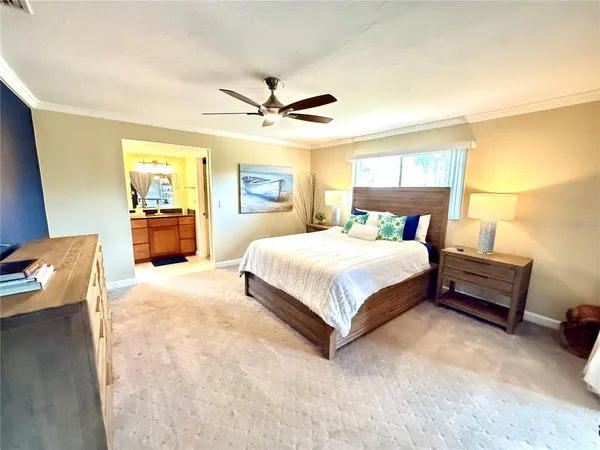 a bedroom with a large bed and a chandelier