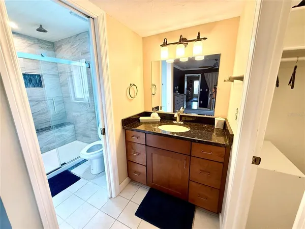 a bathroom with a sink a toilet a mirror and shower