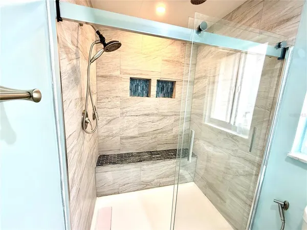 a bathroom with a shower and a glass door