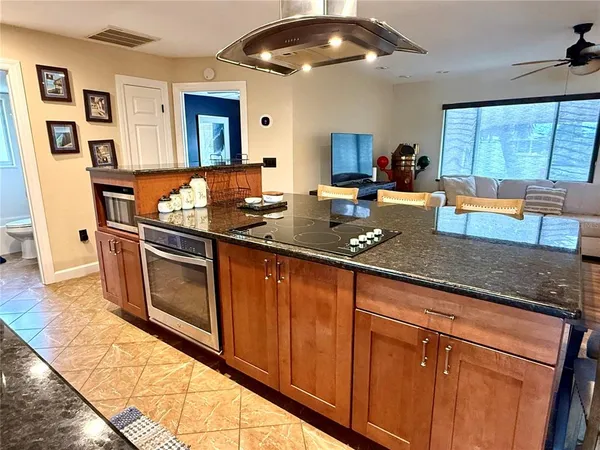 a kitchen with stainless steel appliances granite countertop a sink stove and cabinets