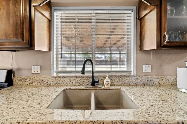a kitchen with granite countertop sink and cabinets
