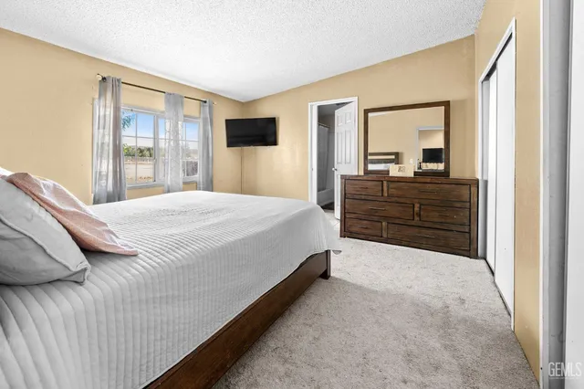 a bedroom with a bed and a large mirror on dresser